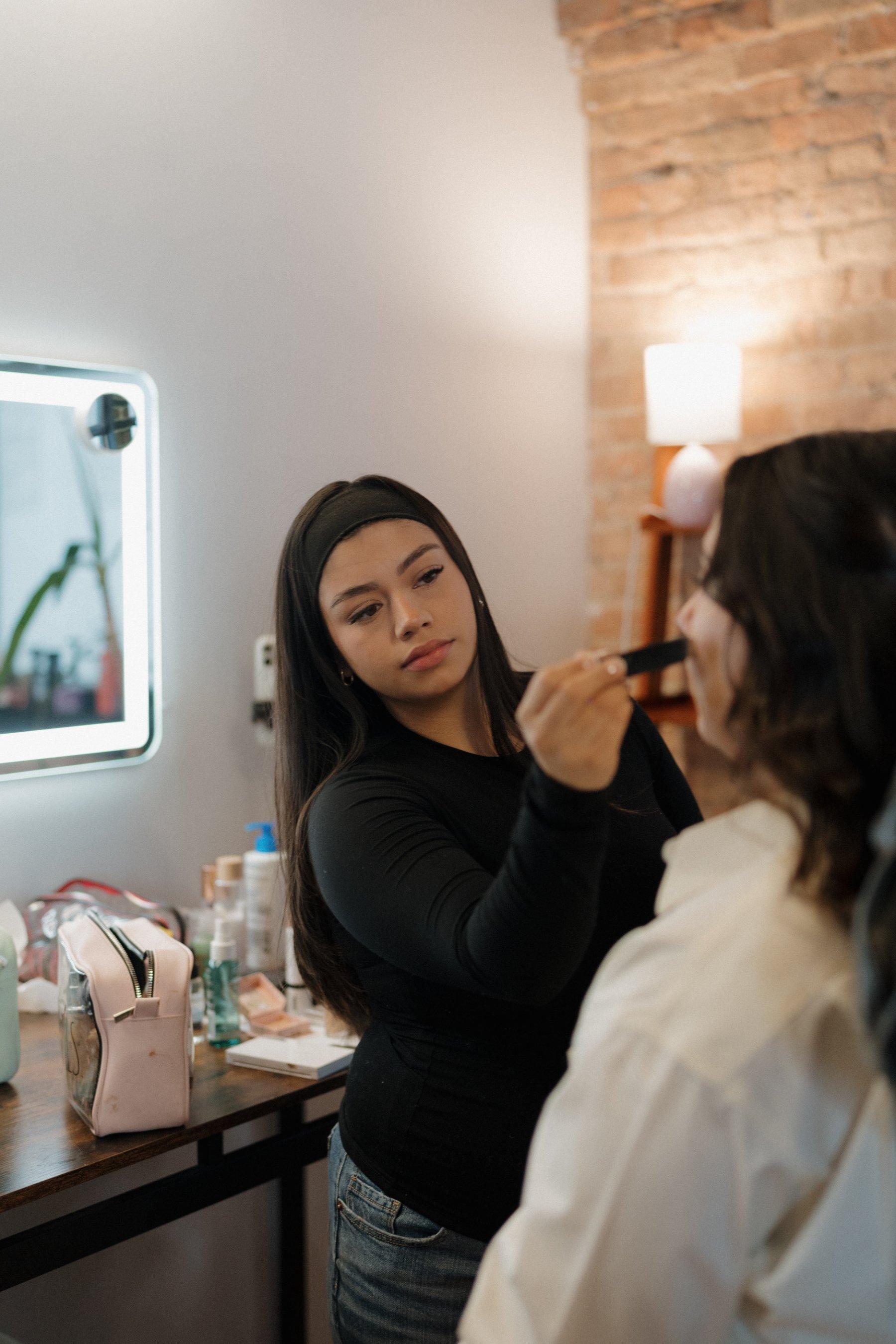 Brenda, founder of House of Beauty, applying makeup to a client